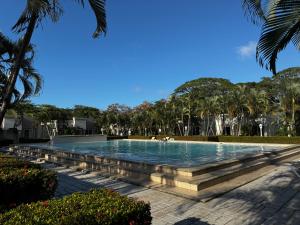 a swimming pool with palm trees in a resort at Villa Bonita in La Ceiba
