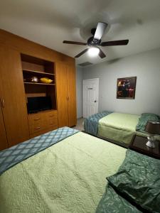 a bedroom with two beds and a ceiling fan at Villa Bonita in La Ceiba +9 photos