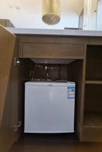 a white refrigerator in a kitchen under a counter at Luke Cloud CTSE-s store in Gangkou