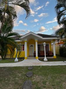 a yellow house with palm trees in front of it at Villa Bonita in La Ceiba