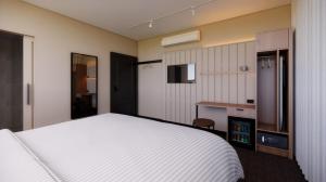 ein Schlafzimmer mit einem großen weißen Bett und einem Fernseher in der Unterkunft Fed Hotel in Semaphore