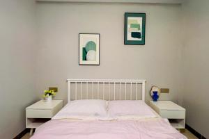 a bedroom with a bed with two white night stands at Luke Cloud RSJA-s store in Gongche