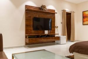 a living room with a flat screen tv on a wall at Hills Pride in Nandi
