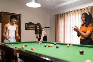 a group of people standing around a pool table at Hills Pride in Nandi +2 photos