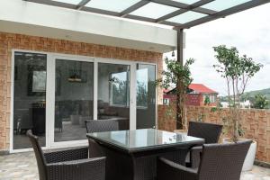 an outdoor patio with a glass table and chairs at Hills Pride in Nandi