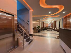 a lobby with a staircase with an orange ceiling at Amazon Garden Suites - Recojo del aeropuerto incluido in Pucallpa