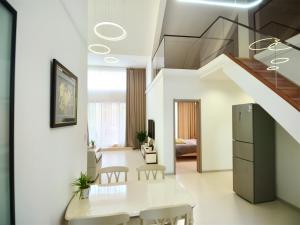 a living room with a dining table and a staircase at Luke Cloud GSHT Store in Luoyang