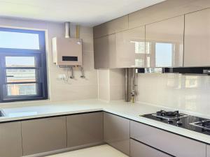 a kitchen with white cabinets and a window at Luke Cloud GSHT Store in Luoyang