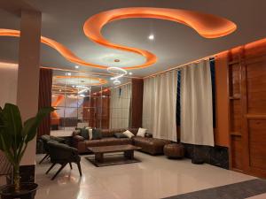 a living room with a couch and a large ceiling at Amazon Garden Suites - Recojo del aeropuerto incluido in Pucallpa
