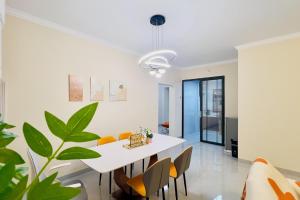 a dining room with a white table and chairs and a plant at Luke Cloud MVHG-s store in Gongche