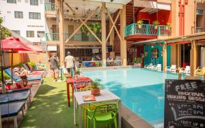 a swimming pool with tables and chairs next to a building at Lub d Siem Reap - Near Pub Street & Angkor Wat in Siem Reap