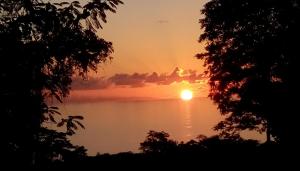 
a sunset view of a lake with trees at Precious Residence C in Grand'Anse
