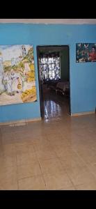 a living room with a blue wall and a tile floor at Finca EL CHACHALACO in Agua Buena