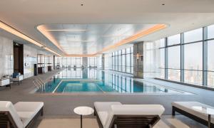 a large swimming pool in a building with windows at Jieyang Marriott Hotel in Jieyang