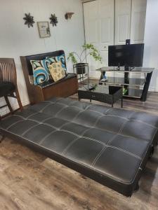 a large black bed in a living room with a tv at Full house close to everything in Sydney