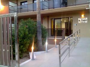 a lobby of a building with a palm tree and lights at Aparthotel El Faro in Cullera