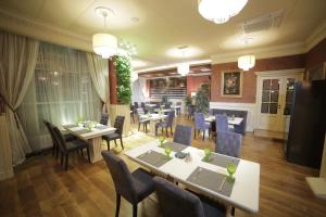 a restaurant with tables and chairs in a room at Aurora in Oktyabrskiy