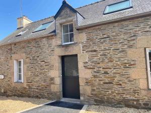 a stone building with a door and a window at La Stracciatella Saint-Aignan in Saint-Aignan