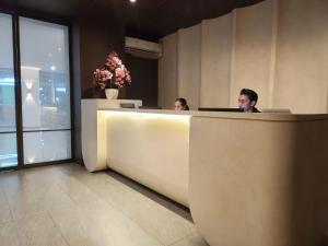 two people sitting at a reception desk in an office at Ow! Hotel Boutique Kemayoran in Jakarta