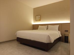 a bedroom with a large bed with white sheets and pillows at Ow! Hotel Boutique Kemayoran in Jakarta