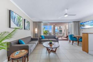 a living room with a couch and a table at Ocean Rise at Airlie Two in Airlie Beach