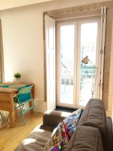 a living room with a couch and a table and a window at Andorinha Apartment in Porto