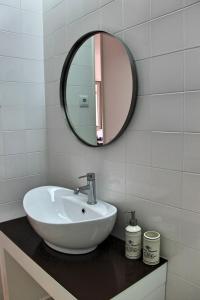 a bathroom with a white sink and a mirror at Andorinha Apartment in Porto