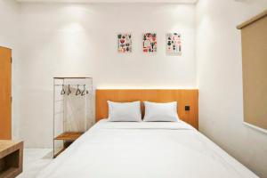 a bedroom with a large bed with white sheets at Adi Inn Homestay RedPartner in Sunggal