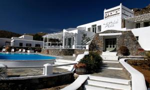 a villa with a swimming pool in front of a building at Olia Hotel in Tourlos
