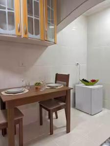a kitchen with a wooden table and two chairs at Loft São Roque U01 Rota do Vinho em São Roque SP in São Roque +25 photos