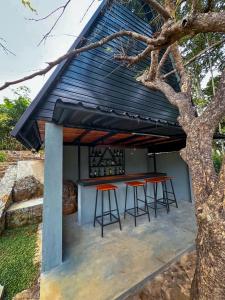 a house with a black roof and orange bar stools at Alpine Heights in Kumburuteniwela