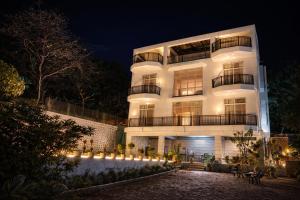 a white building with lights in front of it at HEMGIRI - Private Pool Villa Mulshi in Mulshi