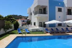 una piscina con sillas y una casa en Vicentina Hotel, en Aljezur