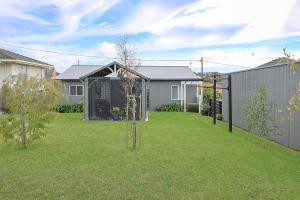 a yard with a fence and some houses at Jimley Cottage in Warrnambool