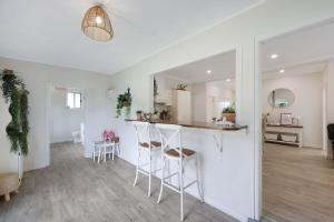 a kitchen and living room with a bar and stools at Jimley Cottage in Warrnambool