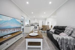 a living room with a couch and a large screen tv at Jimley Cottage in Warrnambool