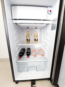 an open refrigerator with bottles of alcohol in it at TAYGA STUDIOS Cancun in Cancún