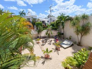 a patio with chairs and palm trees in a backyard at TAYGA STUDIOS Cancun in Cancún