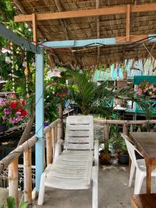 a white chair sitting under a pergola with flowers at New Phiman Riverview Guesthouse in Bangkok