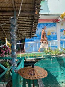 a woman walking across a bridge over a swimming pool at New Phiman Riverview Guesthouse in Bangkok +93 photos