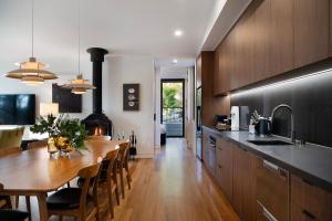 a kitchen with a wooden table and a dining room at Banjo Treehouse in Hepburn Springs