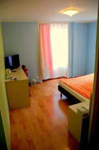 - une chambre avec un lit, un bureau et une fenêtre dans l'établissement Hôtel de l'ours, à Vuiteboeuf