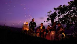 a group of people sitting around a fire at night at Inap Retreat Boutique Cabin Kintamani in Kubupenlokan