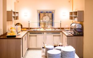 a kitchen with white plates on the counters and a counter top at Hotel zur Seemöwe in Insel Poel
