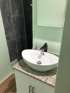 a white sink on a counter in a bathroom at Hibiscus House in Bequia