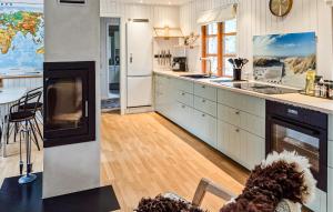 a kitchen with a dog sitting in a chair in a room at Dueodde Ferieby in Neksø