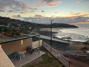 a building with a picnic table and a view of the ocean at EcoDream Lodge in Port Mathurin