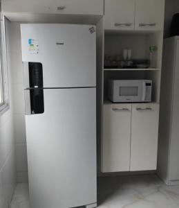 a white refrigerator in a kitchen with a microwave at DR Rbs in Ponta Grossa