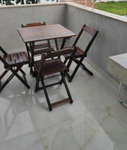 a wooden table and two chairs on a patio at DR Rbs in Ponta Grossa