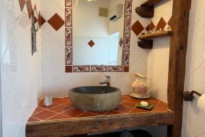 a bathroom with a stone sink and a mirror at Le Clos Lau-Tave Charming 110 m Provençal home with private garden in Simiane-la-Rotonde +50 photos